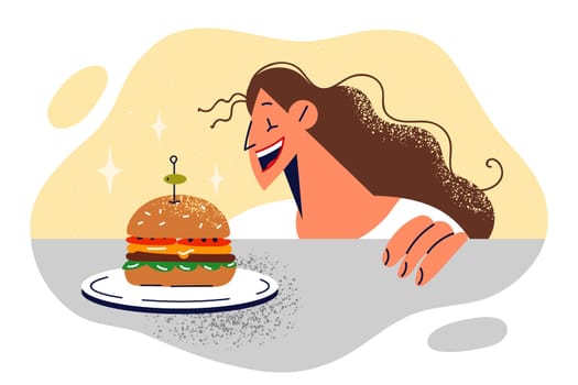 Woman near table with burger smiles in anticipation of delicious lunch in fast food restaurant or street cafe. Junk food addiction metaphor with halestirin causing stomach problems.