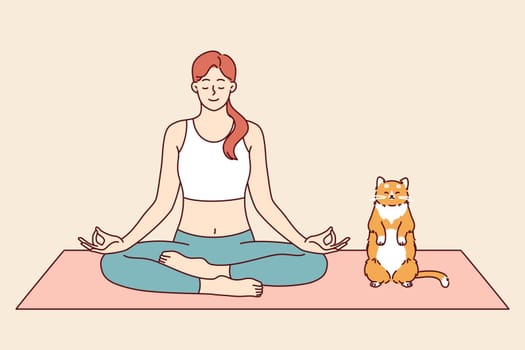 Woman does yoga with cat, meditating in lotus position from zen or asana practice. Pet imitates owner who is keen on yoga and training from buddhist teachings to achieve psychological comfort