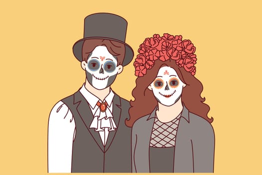 Creepy couple dressed up to celebrate halloween and create scary atmosphere at night party. Young man and woman with painted faces to participate in masquerade on eve of halloween