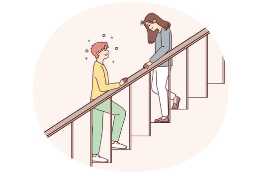 Woman with head down goes down stairs and positive man is waiting for beloved girlfriend downstairs. Teenager in love wants to meet girl whom he met when he climbed stairs