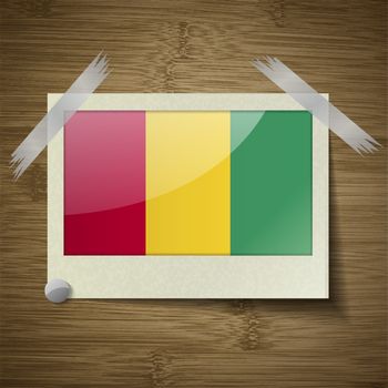 Flags of Guinea at frame on wooden texture. Vector illustration
