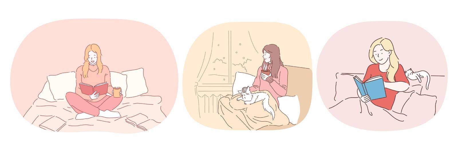 Relaxation with book at home, lazy bedding time concept. Young positive women in comfortable home clothing staying in bed, reading books and relaxing with cat and hot drink at home