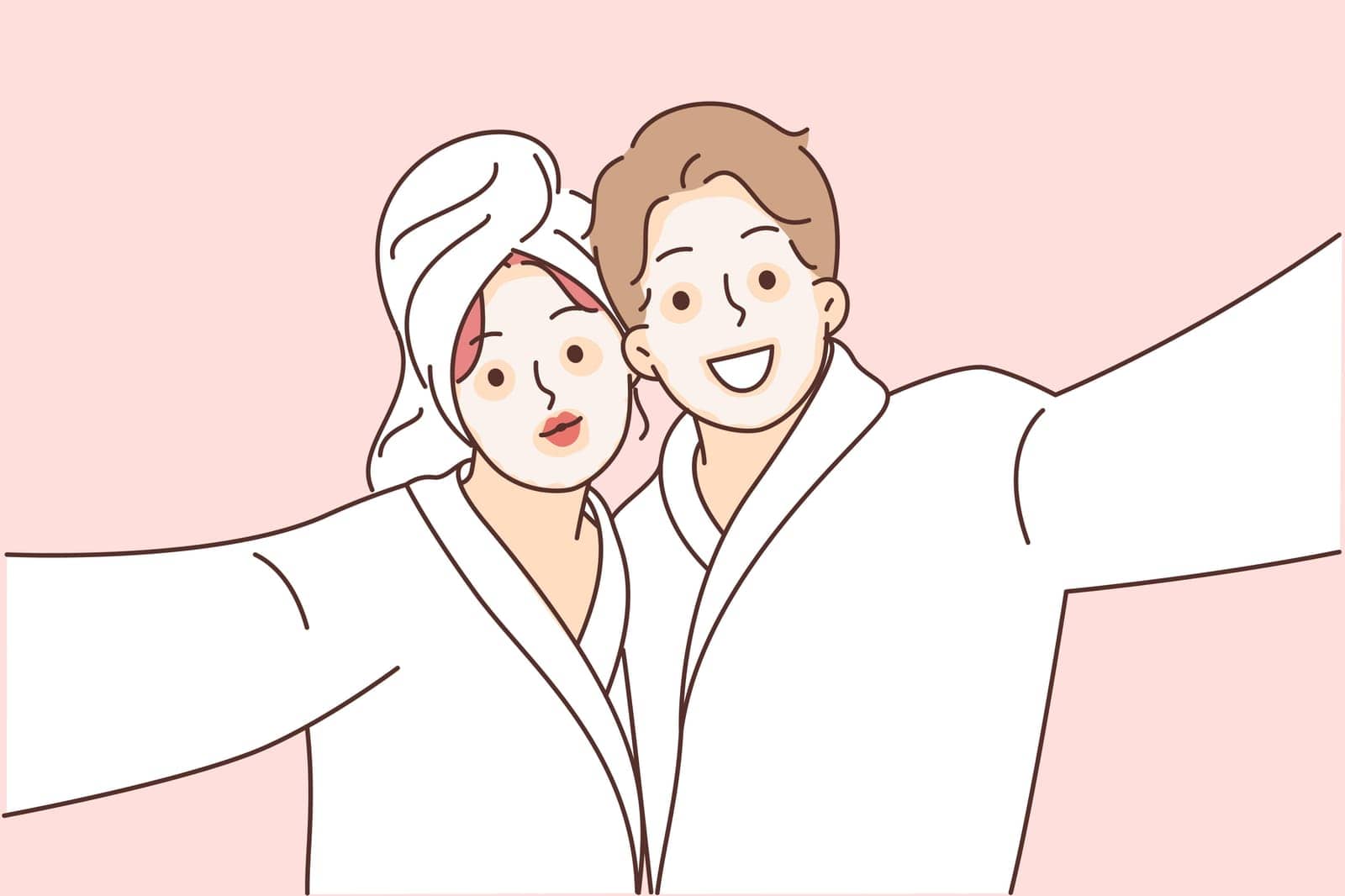 Man and woman with cosmetic masks on faces, dressed in bathrobes to perform SPA treatments. Selfie of happy couple using anti-aging clay cosmetic masks and therapeutic mud for skin tightening